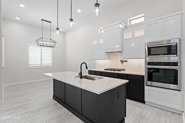 13351 Jeff Winton Dr, El Paso, TX 79928 - kitchen with stainless steel appliances, a sink, light countertops, tasteful backsplash, and an island with sink