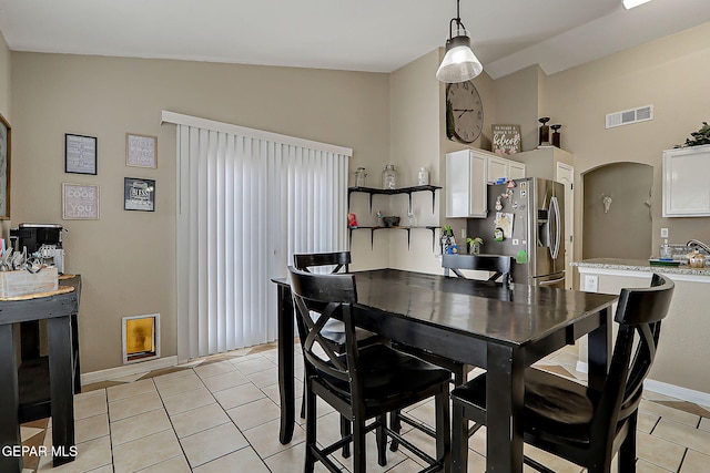 11840 Balladeer Ave, El Paso, TX 79936 - dining area featuring light tile patterned flooring, baseboards, arched walkways, and high vaulted ceiling