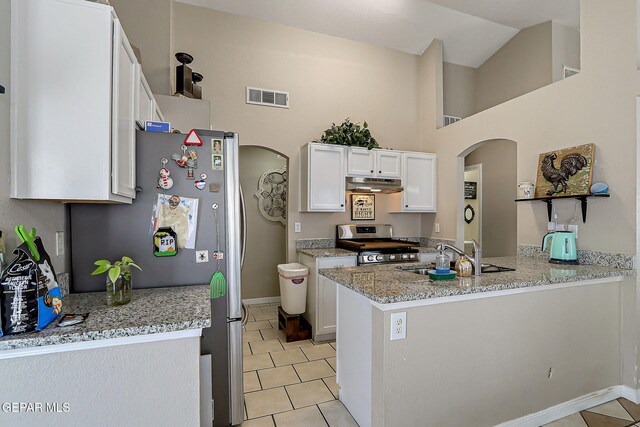 11840 Balladeer Ave, El Paso, TX 79936 - kitchen with stainless steel appliances, arched walkways, under cabinet range hood, a sink, and light tile patterned floors