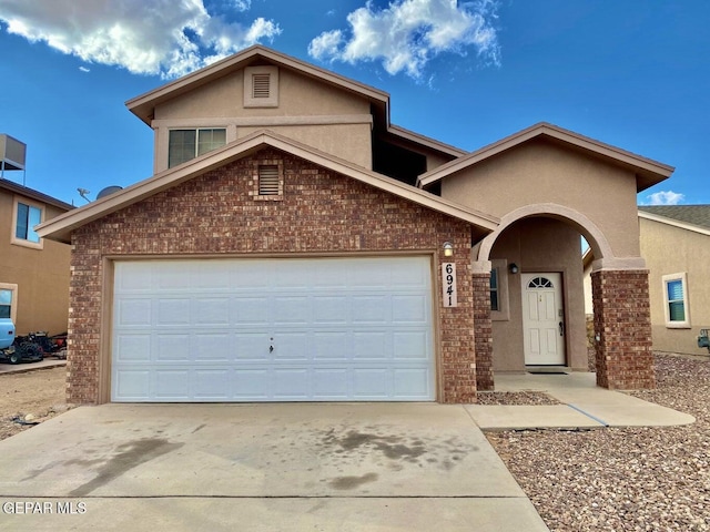 6941 Jericho Tree Dr, El Paso, TX 79934 - view of front of house with concrete driveway, brick siding, stucco siding, and an attached garage