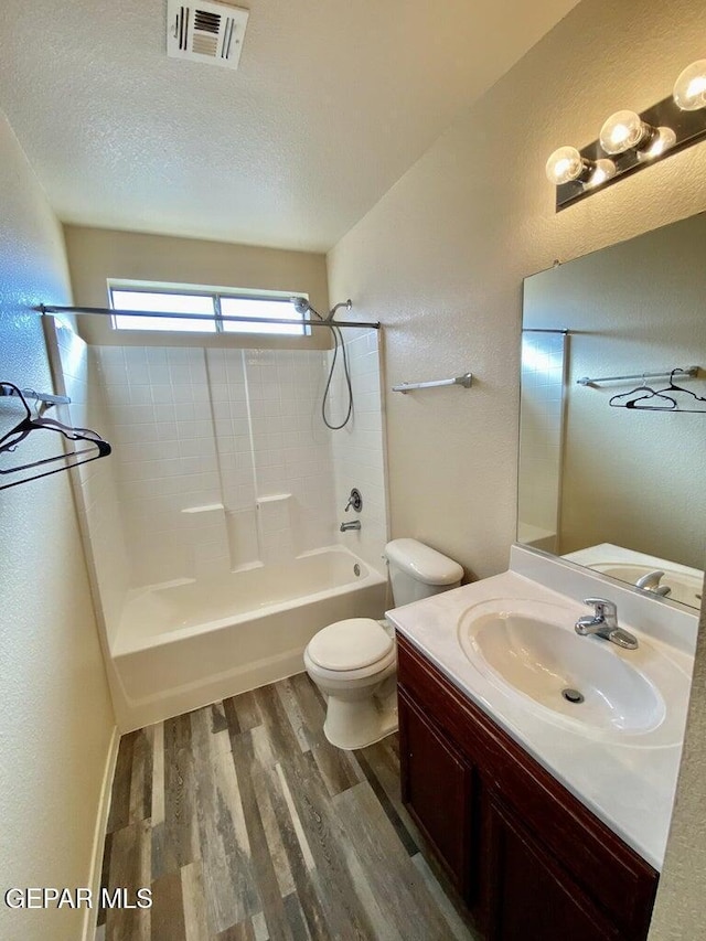 6941 Jericho Tree Dr, El Paso, TX 79934 - full bath featuring shower / bathtub combination, wood finished floors, toilet, vanity, and a textured wall