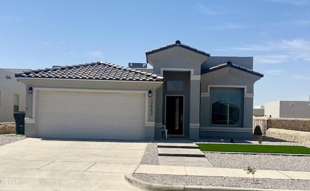 13862 Paseo Bosque Ave, El Paso, TX 79928 - view of front of house with a garage, concrete driveway, a tiled roof, and stucco siding
