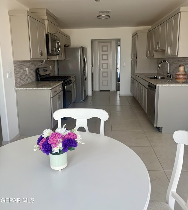 13862 Paseo Bosque Ave, El Paso, TX 79928 - kitchen with appliances with stainless steel finishes, a sink, decorative backsplash, and gray cabinetry