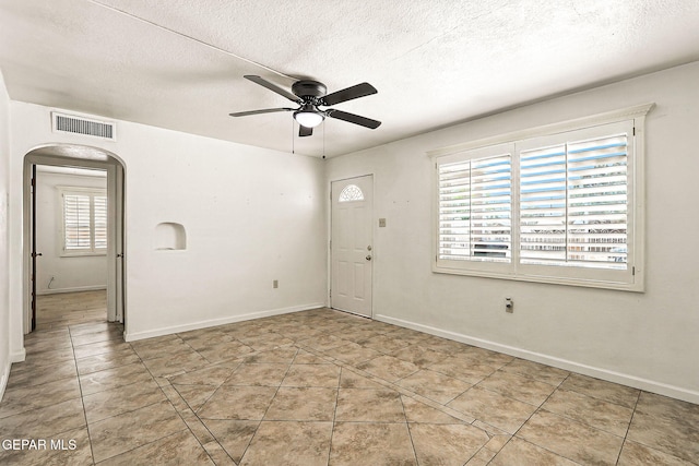 264 Edith Dr, El Paso, TX 79915 - spare room with a ceiling fan, arched walkways, a textured ceiling, and tile patterned flooring