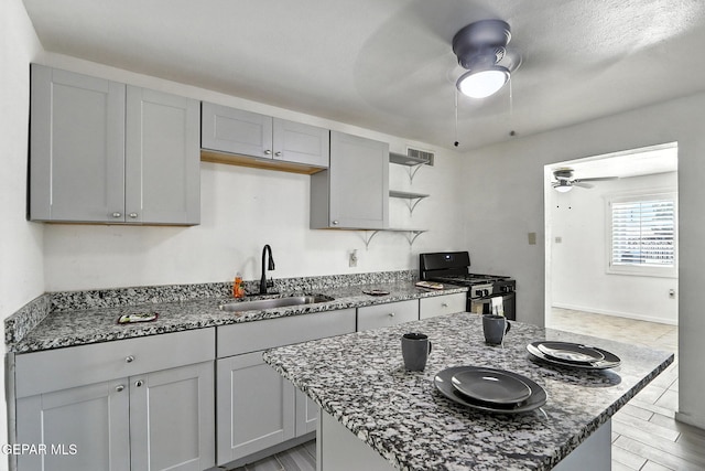 264 Edith Dr, El Paso, TX 79915 - kitchen featuring stainless steel gas range oven, a ceiling fan, stone counters, and open shelves
