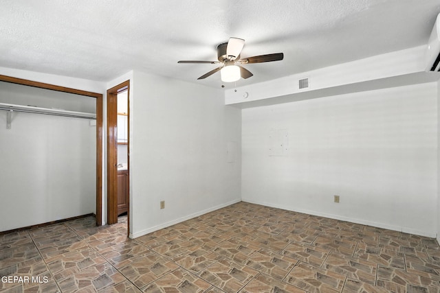 264 Edith Dr, El Paso, TX 79915 - unfurnished bedroom with stone finish flooring, a textured ceiling, a closet, and ceiling fan