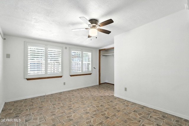 264 Edith Dr, El Paso, TX 79915 - unfurnished bedroom with stone finish flooring, a textured ceiling, ceiling fan, and a closet