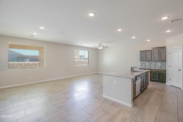 14737 Tierra Escape Ave, El Paso, TX 79938 - kitchen with a ceiling fan, tasteful backsplash, light stone countertops, recessed lighting, and an island with sink