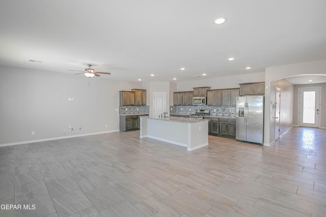 14737 Tierra Escape Ave, El Paso, TX 79938 - kitchen featuring appliances with stainless steel finishes, arched walkways, open floor plan, ceiling fan, and tasteful backsplash
