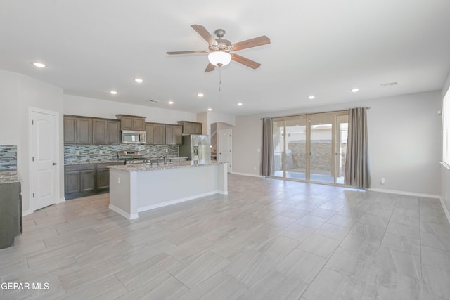 14737 Tierra Escape Ave, El Paso, TX 79938 - kitchen featuring appliances with stainless steel finishes, a ceiling fan, backsplash, open floor plan, and an island with sink
