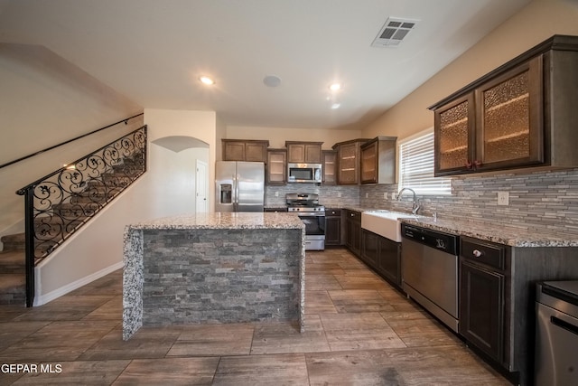 12320 Desert Path Ct, El Paso, TX 79938 - kitchen featuring stainless steel appliances, light stone counters, arched walkways, decorative backsplash, and recessed lighting