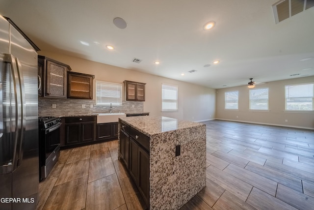 12320 Desert Path Ct, El Paso, TX 79938 - kitchen with stainless steel fridge, range with gas cooktop, a sink, ceiling fan, and glass insert cabinets