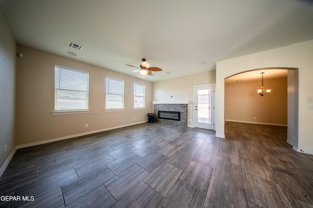 12320 Desert Path Ct, El Paso, TX 79938 - unfurnished living room featuring ceiling fan, dark wood-type flooring, arched walkways, and a fireplace