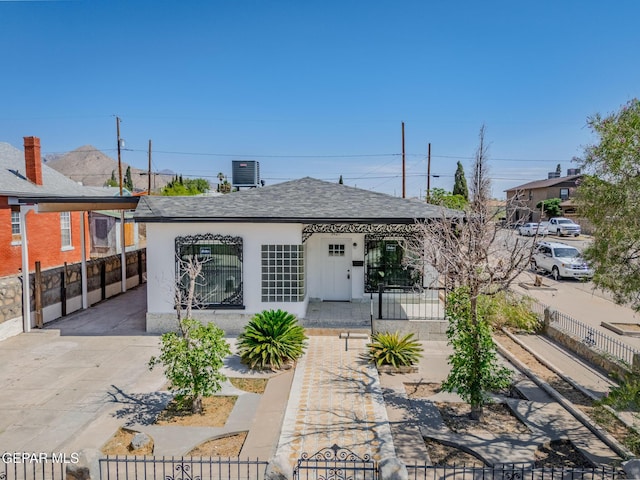 3427 Hamilton Ave, El Paso, TX 79930 - back of property with a fenced front yard, central AC, roof with shingles, a carport, and stucco siding