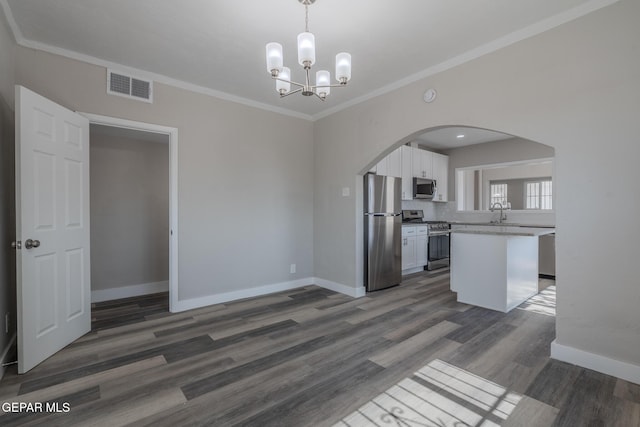 3427 Hamilton Ave, El Paso, TX 79930 - kitchen with appliances with stainless steel finishes, arched walkways, white cabinetry, baseboards, and crown molding
