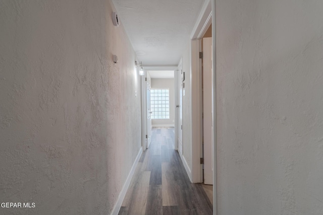 3427 Hamilton Ave, El Paso, TX 79930 - corridor with wood finished floors, a textured wall, and baseboards