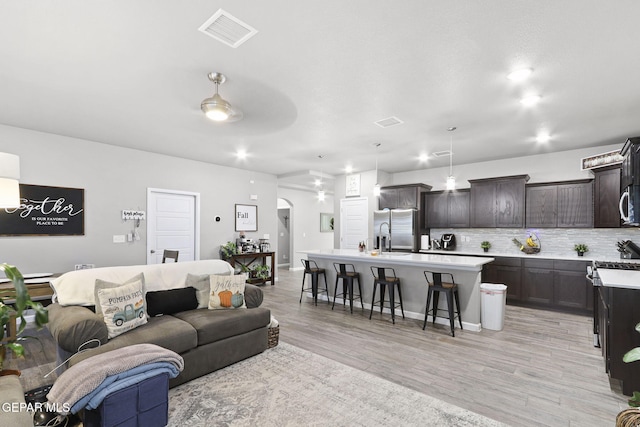 2528 Mike Price Dr, El Paso, TX 79938 - living area featuring light wood-type flooring, arched walkways, and recessed lighting