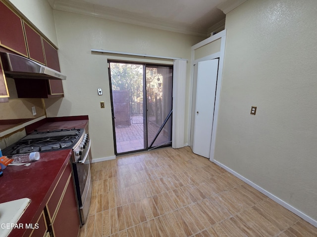 441 Irondale Dr, El Paso, TX 79912 - kitchen with ornamental molding, gas stove, dark countertops, baseboards, and under cabinet range hood