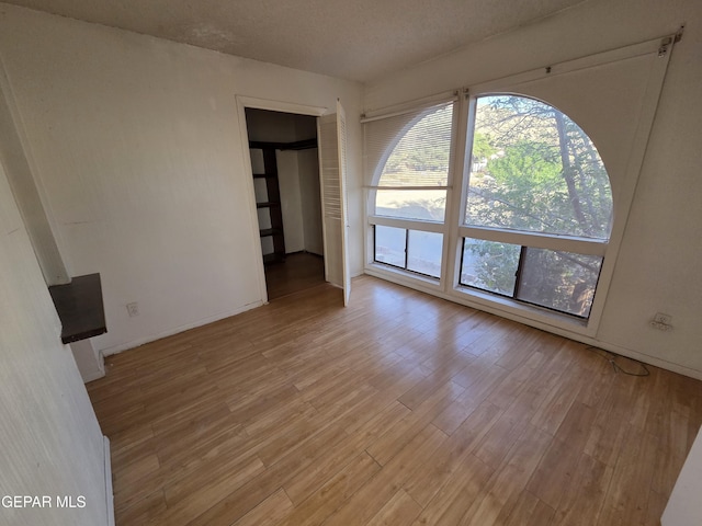 441 Irondale Dr, El Paso, TX 79912 - empty room with light wood-style floors, baseboards, and a textured ceiling