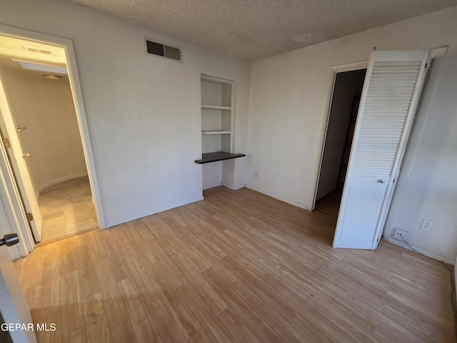 441 Irondale Dr, El Paso, TX 79912 - unfurnished bedroom with light wood finished floors, a textured ceiling, and baseboards