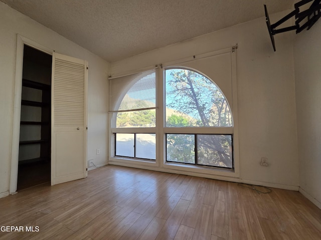 441 Irondale Dr, El Paso, TX 79912 - unfurnished bedroom featuring a textured ceiling, light wood-style floors, and baseboards