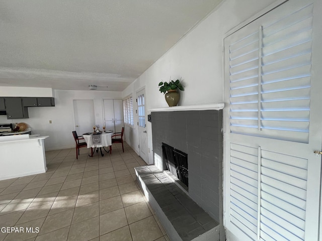 3208 Lampliter Pl, El Paso, TX 79925 - living area with light tile patterned floors, a brick fireplace, baseboards, and a textured ceiling