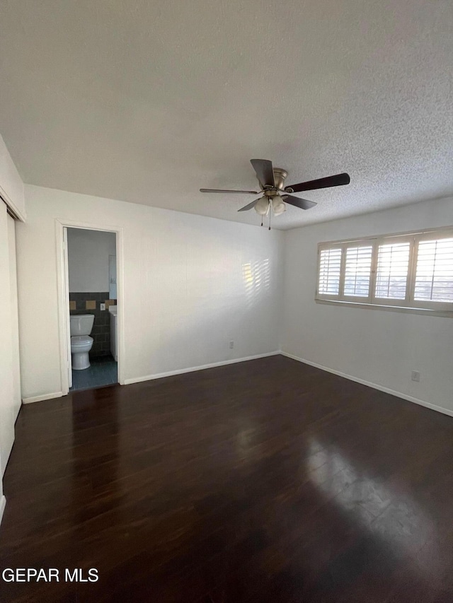 3208 Lampliter Pl, El Paso, TX 79925 - unfurnished bedroom featuring dark wood-style floors, baseboards, and connected bathroom