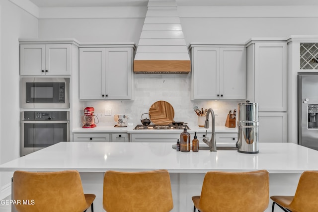 13107 Kington Ave, El Paso, TX 79928 - kitchen with stainless steel appliances, premium range hood, light countertops, and decorative backsplash