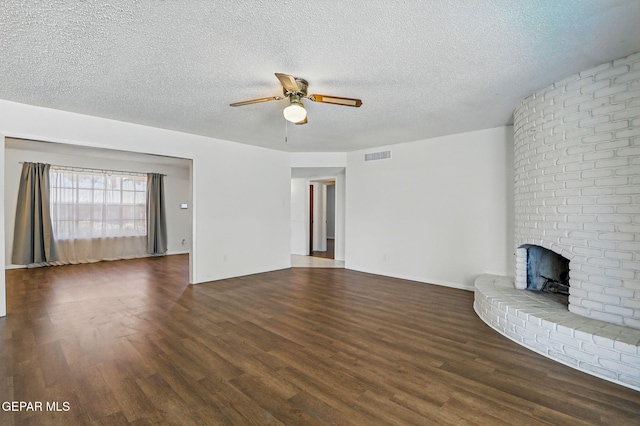 9204 Rex Ct, El Paso, TX 79925 - unfurnished living room featuring dark wood finished floors, ceiling fan, a textured ceiling, and a brick fireplace