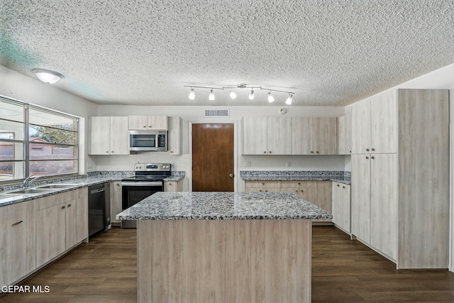 9204 Rex Ct, El Paso, TX 79925 - kitchen featuring appliances with stainless steel finishes, a sink, light brown cabinetry, a center island, and dark wood finished floors