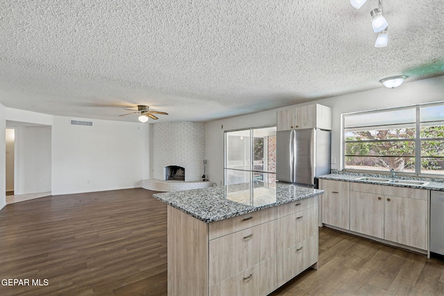 9204 Rex Ct, El Paso, TX 79925 - kitchen featuring a sink, freestanding refrigerator, a textured ceiling, light brown cabinets, and dark wood-style flooring