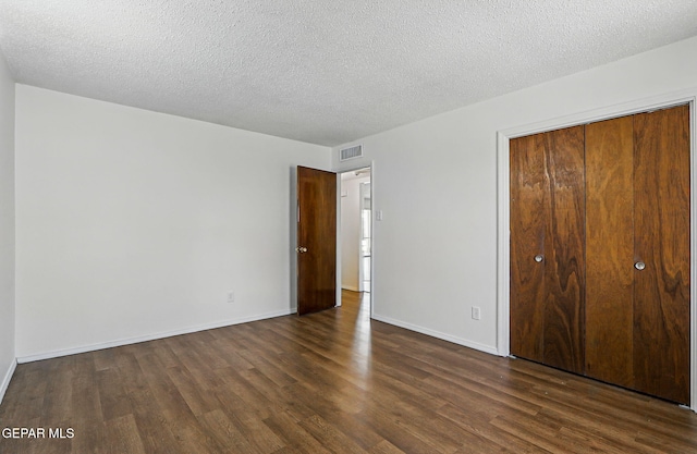 9204 Rex Ct, El Paso, TX 79925 - unfurnished bedroom featuring dark wood-style floors, baseboards, a closet, and a textured ceiling