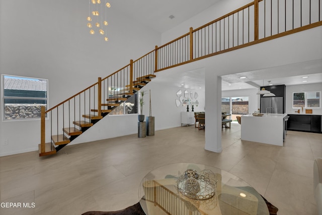 11316 Menlo Ave, El Paso, TX 79936 - living room featuring a towering ceiling, stairway, a chandelier, and baseboards