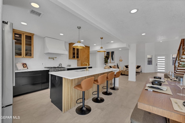11316 Menlo Ave, El Paso, TX 79936 - kitchen featuring custom exhaust hood, a sink, a center island with sink, recessed lighting, and light countertops