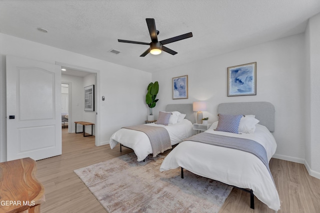 11316 Menlo Ave, El Paso, TX 79936 - bedroom with light wood-type flooring, baseboards, ceiling fan, and a textured ceiling