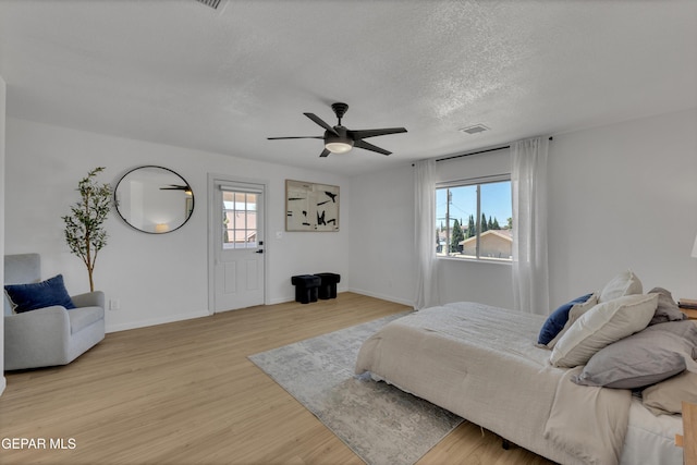 11316 Menlo Ave, El Paso, TX 79936 - bedroom featuring multiple windows, light wood-style flooring, baseboards, and a textured ceiling