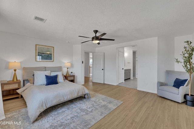 11316 Menlo Ave, El Paso, TX 79936 - bedroom featuring wood finished floors, a textured ceiling, baseboards, connected bathroom, and ceiling fan
