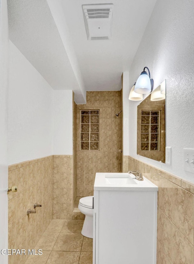 1117 Zuni Pl, El Paso, TX 79925 - full bathroom with tile walls, toilet, vanity, tile patterned floors, and a shower