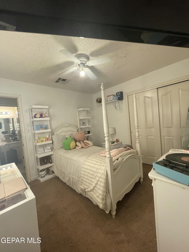 1360 Luz Carpio Way, El Paso, TX 79936 - bedroom featuring a closet, dark colored carpet, ceiling fan, and a textured ceiling