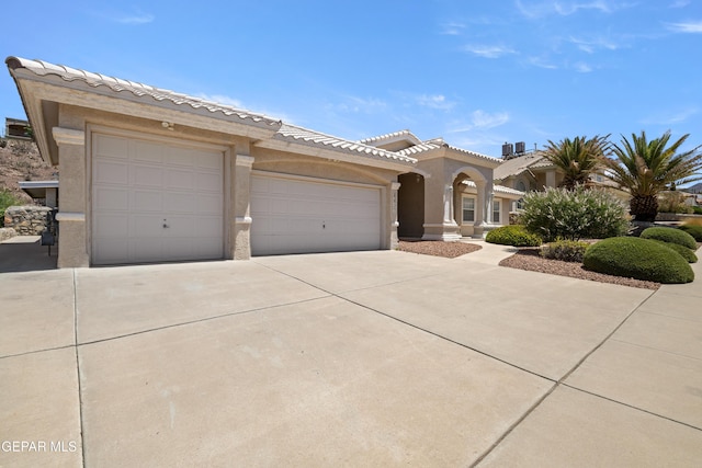 6637 Wind Ridge Dr, El Paso, TX 79912 - view of front of property with concrete driveway, stucco siding, an attached garage, and a tile roof