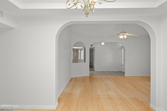 6637 Wind Ridge Dr, El Paso, TX 79912 - spare room with arched walkways, a chandelier, wood finished floors, and ceiling fan
