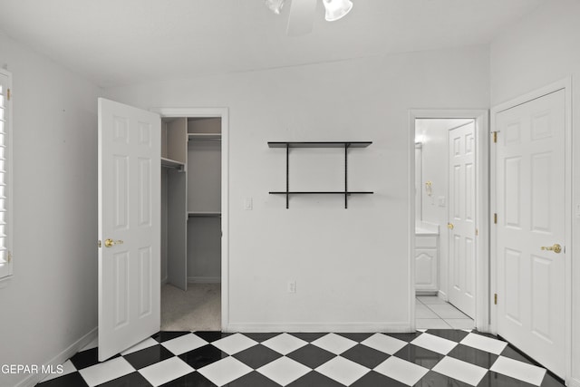 6637 Wind Ridge Dr, El Paso, TX 79912 - unfurnished bedroom with a spacious closet, connected bathroom, tile patterned floors, and a closet