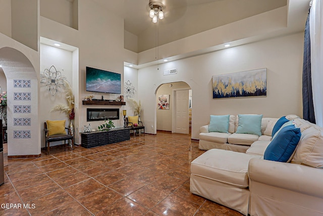 6112 Strahan Rd, El Paso, TX 79932 - living area with arched walkways, ceiling fan, baseboards, and a high ceiling