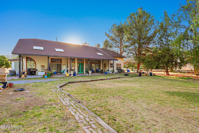 6112 Strahan Rd, El Paso, TX 79932 - rear view of property featuring a lawn, a patio, and stucco siding