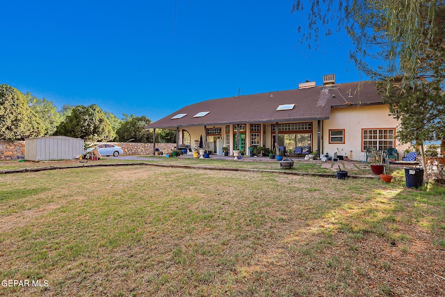 6112 Strahan Rd, El Paso, TX 79932 - rear view of property with a lawn, a patio, stucco siding, and an outbuilding