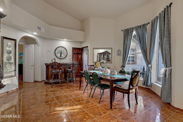 6112 Strahan Rd, El Paso, TX 79932 - dining area with arched walkways, tile patterned floors, baseboards, and vaulted ceiling