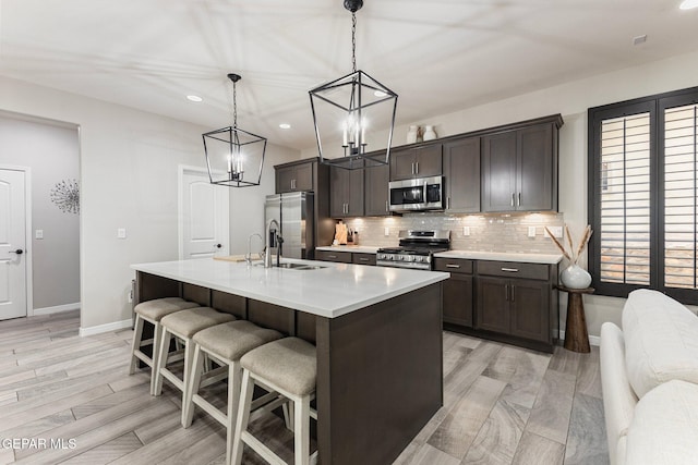 14689 Pebble Hills Blvd, El Paso, TX 79938 - kitchen with appliances with stainless steel finishes, recessed lighting, dark brown cabinetry, light countertops, and a kitchen bar