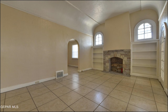 2619 Piedras St Unit A, And B, El Paso, TX 79930 - unfurnished living room with vaulted ceiling, light tile patterned flooring, built in shelves, baseboards, and arched walkways