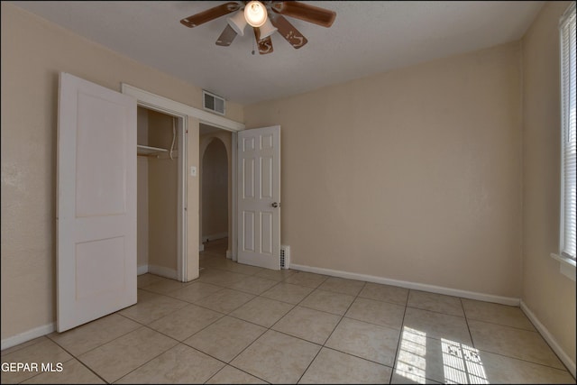 2619 Piedras St Unit A, And B, El Paso, TX 79930 - unfurnished bedroom featuring light tile patterned flooring, arched walkways, a closet, ceiling fan, and baseboards