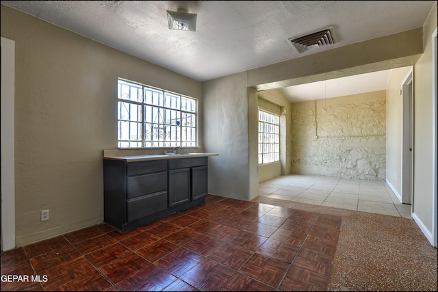 2619 Piedras St Unit A, And B, El Paso, TX 79930 - spare room featuring a sink, a textured ceiling, a textured wall, and baseboards